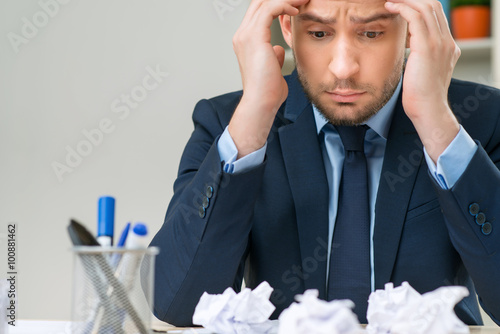 Nice worker playing with paper at the table 