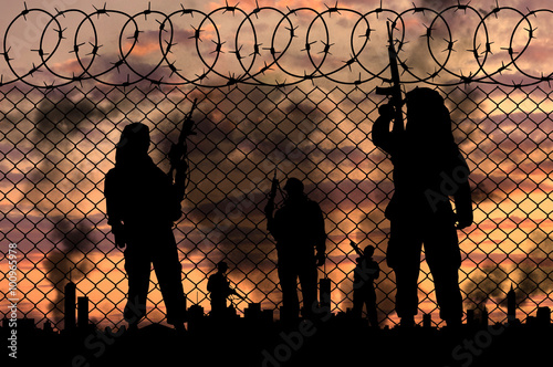 Silhouette terrorists near the border fence