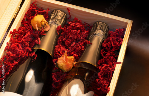 Skrzynka z butelkami szampana i żółte róże.