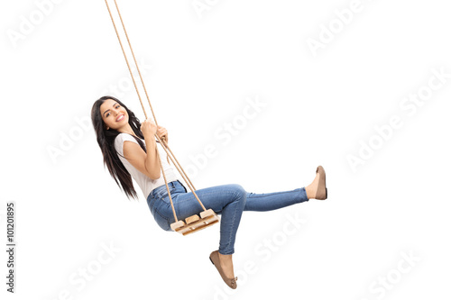 Young carefree girl swinging on a swing