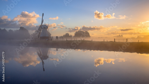 White Historic windmill in morning fog