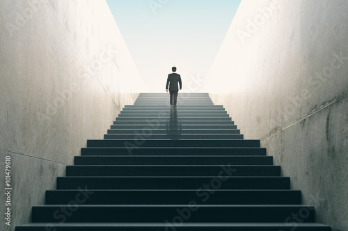 Ambitions concept with businessman climbing stairs