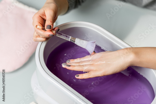 Female hands in a paraffin wax bowl