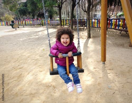 Niña sonriente en el columpio