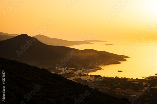Landscape view of dramatic ocean coastline and port at sunset