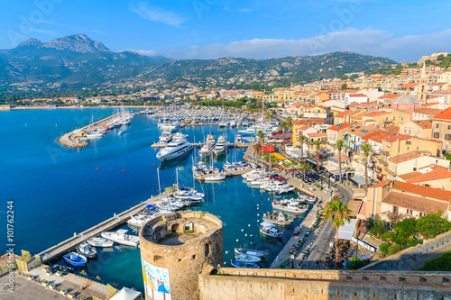 CALVI, CORSICA ISLAND - JUN 29, 2015: view of boats and colorful houses in Calvi port. This town has luxurious marina and is very popular tourist destination.