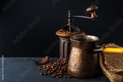 Coffee mill and cezve on the dark table horizontal