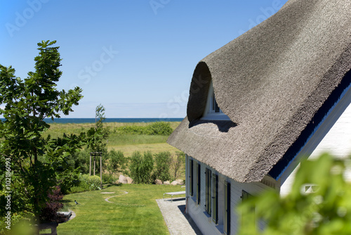 historical house with thatched roof and blue sky at the German Baltic Sea coast, Germany, Europe