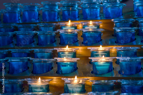 Dark artistic blue glass votive candles with selective focus and