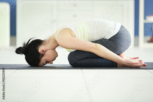 Health concept. Young attractive woman does yoga exercise in the room