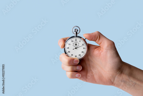 timer held in hand, blue background