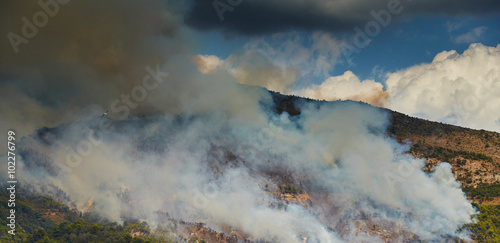 Italy, Ventimiglia, 2015.09.09: Fire in the forest mountain in the Italian town of Ventimiglia, all the mountains in the smoke, the villa is on fire, the fire service aircraft extinguish a fire