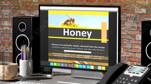 Monitor with Honey information on desktop with office objects.