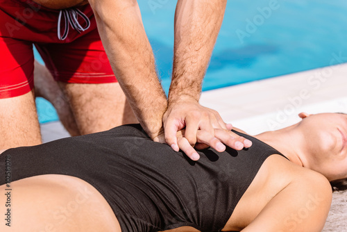 Swimming pool lifeguard performing chest compressions 