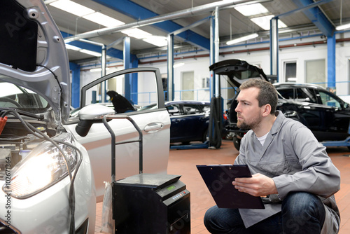 Gutachter untersucht Auto in einer Werkstatt - TÜV Kontrolle in Deutschland
