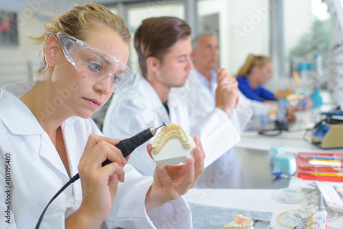 Dental technician grinding tooth