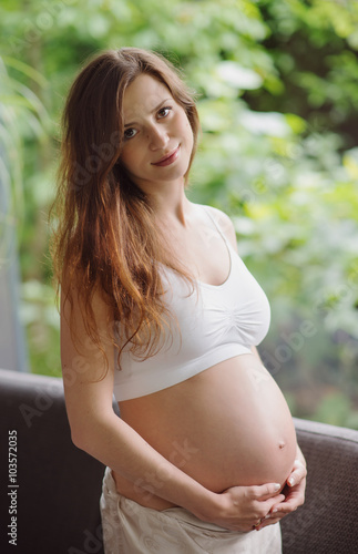 beautiful pregnant woman standing with belly
