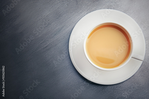 Porcelain cup of tea with milk on gray background