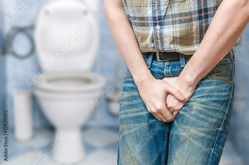 Incontinence concept. Man wants to pee and is holding his bladder.