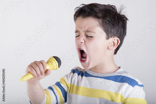 niño cantando con un micrófono 