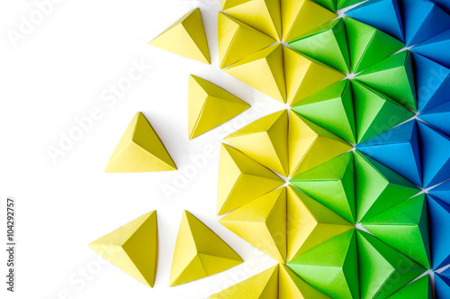 Origami tetrahedrons background. Futuristic polygonal composition with copy space on the left side.