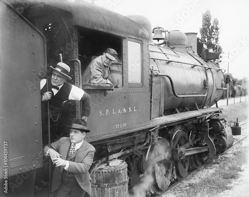 Three men waiting at a steam locomotive 