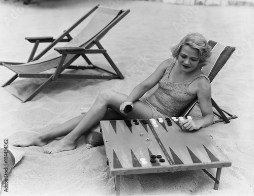 Woman playing backgammon on beach 