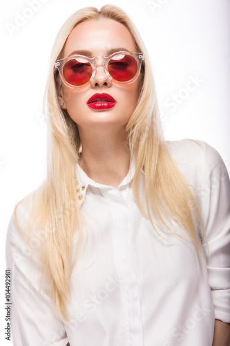 Beautiful blonde girl in pink glasses and shirt. Beauty face. Isolated on white background.
