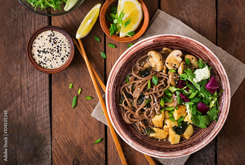 Miso and soba noodle soup with roasted tofu and mushrooms. Top view