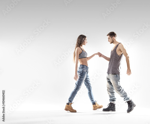Handsome b-boy dancing with a slim girl