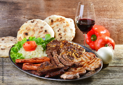 Wholesome platter of mixed meats including grilled steak. Balkan food