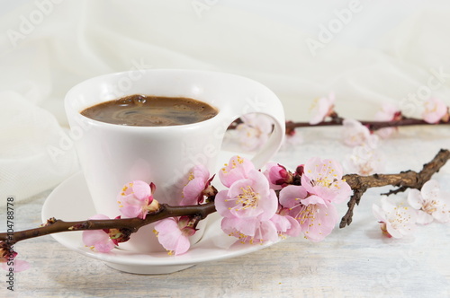 Cup of coffee with cherry blossom flowers