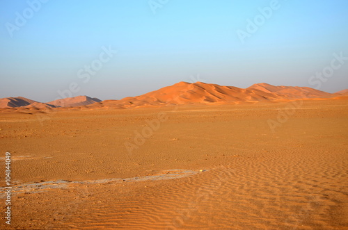 Sand dune hill on empty plane in desert Oman