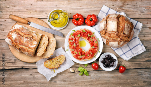 Mediterranean snack. Frisella tomato and basil with olive oil, bruschetta with oregano, bread, tomatoes and castelvetrano olives 