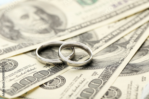Silver wedding rings on one hundred dollars bill background
