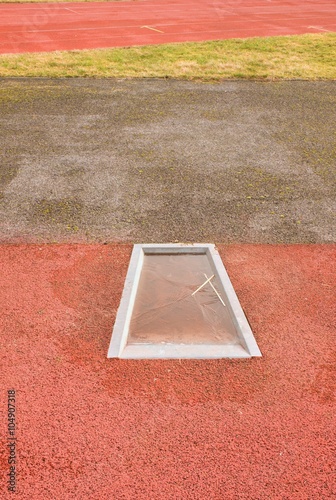 Detail of take-off board on track and field for pole vault high jump. Winter season