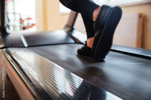 Treadmill used by sportswoman for running in gym