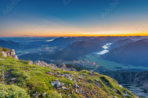 view from top of mountain to valley with lake plansee at sunrise