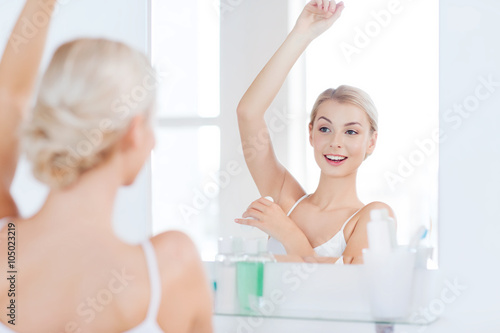 woman with antiperspirant deodorant at bathroom
