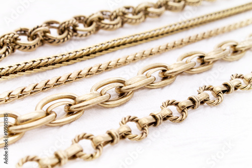 Beautiful Antique Gold Chains in Selective Focus on a White Background