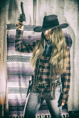 Cowgirl Gunslinger Standing Gun Up. Old west cowgirl gunslinger standing with peacemaker gun held up, edited in vintage film style.