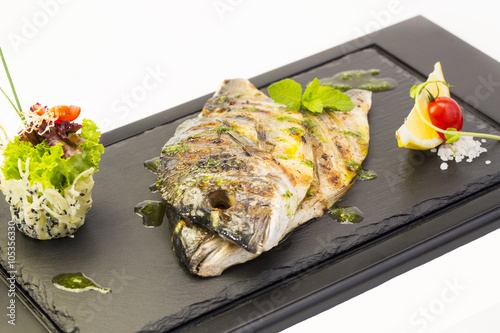Fried fish dorado with vegetables and lemon