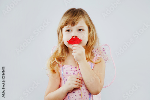 Little fairy posing with paper lips on white background