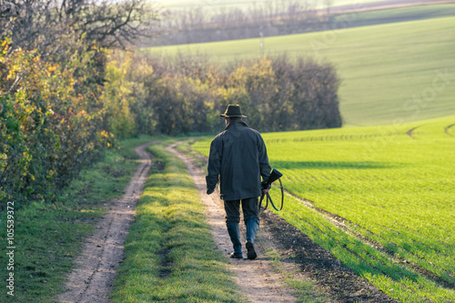 Scenic view of gamekeeper walks over field.