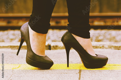 femme marchant avec chaussures à hauts-talons sur quai de gare