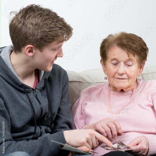 oma schaut mit enkel alte fotos