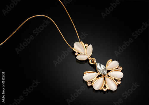 Golden Jewellery pendant with nacre and diamonds on darck backgr