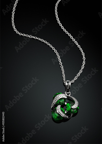 jewelry pendant with green emerald on darck background