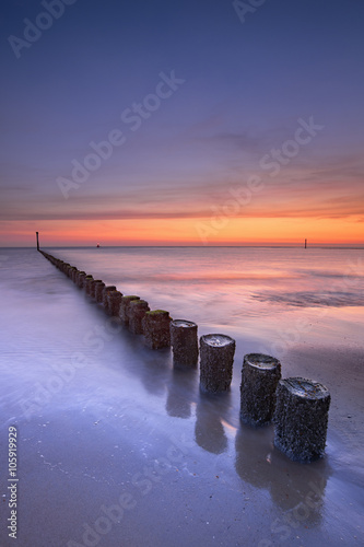 Breakwater on the beach at sunset in Zeeland, The Netherlands