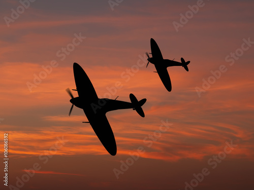 Silhouette of Vintage British World War 2 fighters against the evening sky. - Artists Impression.
